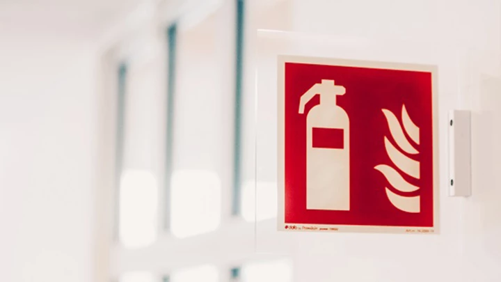 Systematiskt brandskyddsarbete Skylt på vägg som visar brandsläckare och lågor. Bilden sammanfattar innebörden av systematiskt brandskyddsarbete.