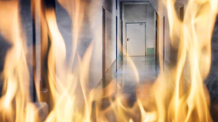 Eldflammor framför korridor.